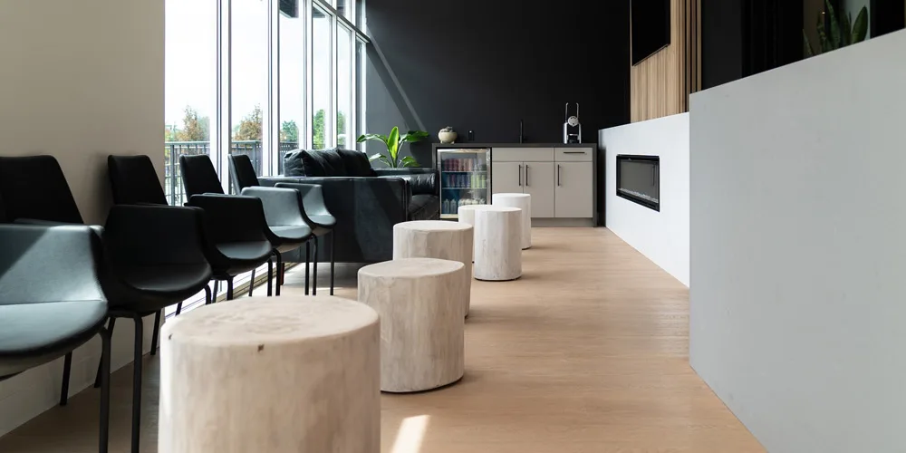The waiting room, with tree-stump stools, black chairs and tall windows